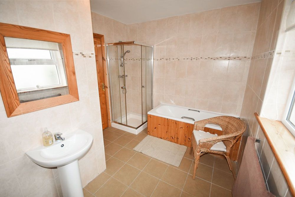 Large bathroom containing bath and power shower